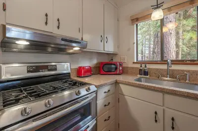 a kitchen with a stove and a sink and a microwave at Cozy Pet-Friendly Cabin w Fenced-In Yard Close to Slopes Beach Town in Carnelian Bay