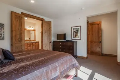 a bedroom with a bed and a dresser and a mirror at Lodges 1112 - 3 Bed townhome with Loft in Mammoth Lakes