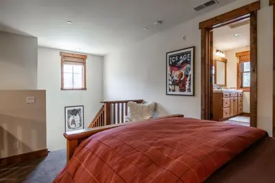 a bedroom with a large bed and a bathroom at Lodges 1112 - 3 Bed townhome with Loft in Mammoth Lakes