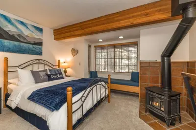 a bedroom with a bed and a wood stove at Donner Lake Inn in Truckee