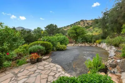 a stone driveway with plants and a stone wall at SEQUOIA LOOKOUT LODGE in Three Rivers