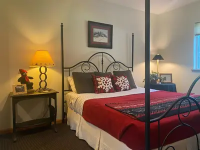 a bedroom with a bed with a red comforter at Large Family Home in Quiet Wooded Setting Close to Everything in Mevers