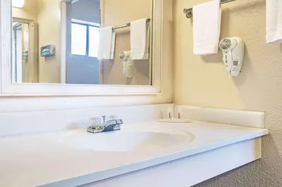 a bathroom with a sink and a mirror at Travelodge by Wyndham Turlock in Turlock