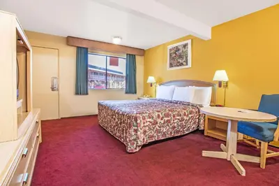 a hotel room with a bed and a table at Travelodge by Wyndham Turlock in Turlock
