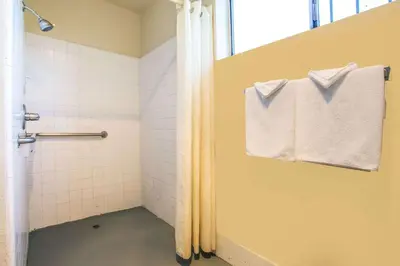 a bathroom with a shower with a towel on a window at Travelodge by Wyndham Turlock in Turlock