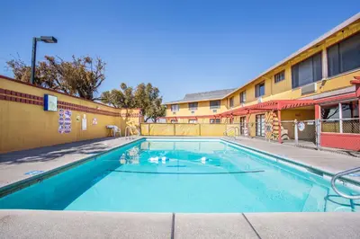 a swimming pool in front of a building at Travelodge by Wyndham Turlock in Turlock
