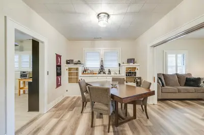 a dining room and living room with a table and chairs at Sunny Turlock Cottage Walk to Downtown! in Turlock