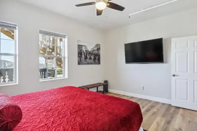 a bedroom with a red bed and a flat screen tv at Mtn-View Apt with Deck in Historic Virginia City in Virginia City