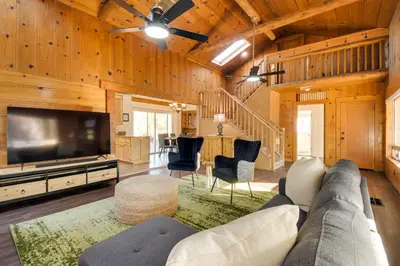 a living room with a couch and a flat screen tv at Waterfront Mariposa Vacation Rental with Hot Tub in Mariposa