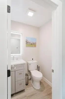 a white bathroom with a toilet and a sink at Dennison House in Three Rivers