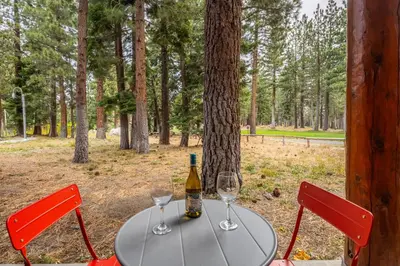 a table with two glasses and a bottle of wine at Cabins 1 in Mammoth Lakes