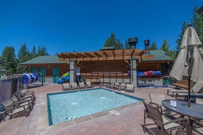 a swimming pool with chairs and a table and umbrella at 3BR Tahoe Donner Cabin with HOA Perks like Pools Hot-Tub Minutes to Trails Lake Golf in Truckee