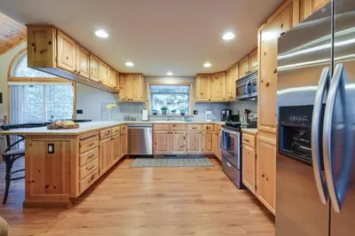a kitchen with wooden cabinets and stainless steel appliances at 4 Mi to Downhill Ski Resort! Spacious Family Haven in Truckee