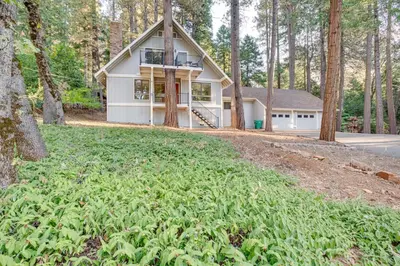 a house in the woods with a large field at Pollock Pines Cabin Game Room with AandC and Heat! in Pollock Pines