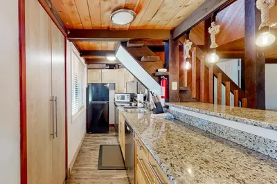 a kitchen with granite counter tops and a refrigerator at Hilltop Lodge in Stateline