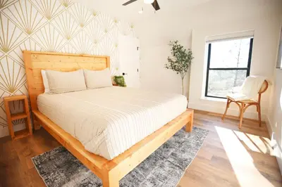 a bedroom with a bed and a chair and a window at High End A-Frame - Hot Tub - Awesome Views - Yosemite - Electric Vehicle Friendly - Sleeps 10 in Oakhurst