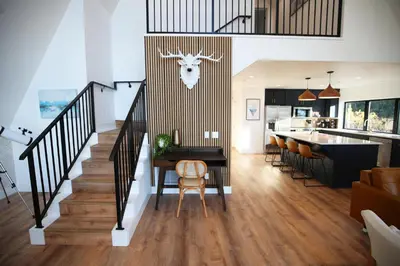 a kitchen and living room with a staircase and a table and chairs at High End A-Frame - Hot Tub - Awesome Views - Yosemite - Electric Vehicle Friendly - Sleeps 10 in Oakhurst