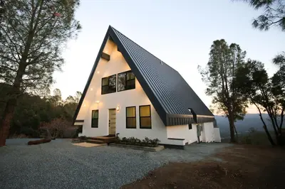 a house with a gambrel roof on a hill at High End A-Frame - Hot Tub - Awesome Views - Yosemite - Electric Vehicle Friendly - Sleeps 10 in Oakhurst