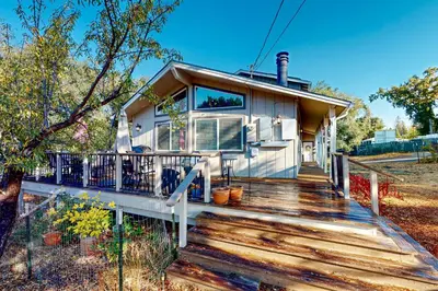 a house on a wooden deck with a porch at Red Umbrella Hideaway in Groveland