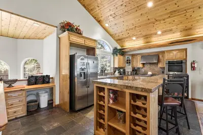 a kitchen with wooden cabinets and a stainless steel refrigerator at Getting Away Together home in South Lake Tahoe