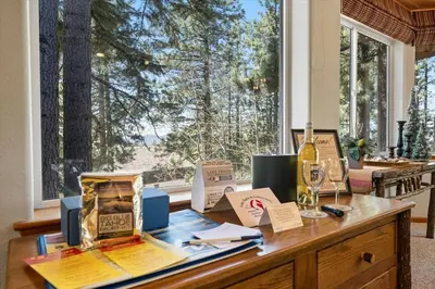 a table with a bottle of wine and a window at Getting Away Together home in South Lake Tahoe