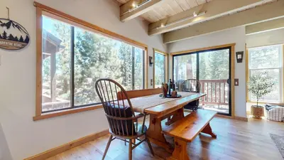 a dining room with a table and chairs and windows at Val D'Isere #8 condo in Mammoth Lakes