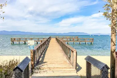 a wooden bridge over the water with two benches at Lakeland Village South Lake Tahoe in South Lake Tahoe
