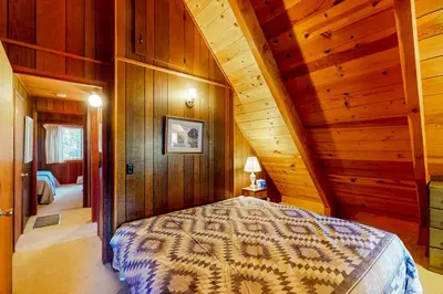 a bedroom with a bed in a room with wooden walls at Tranquil Treehouse Haven in Tahoe City
