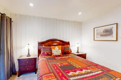 a bedroom with a bed with two night stands and two lamps at Sierra Park Villas 11 C in Mammoth Lakes