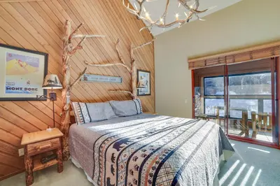 a bedroom with a bed and a wooden wall at Mammoth Lakes Condo - Steps to Ski Lift! in Mammoth Lakes