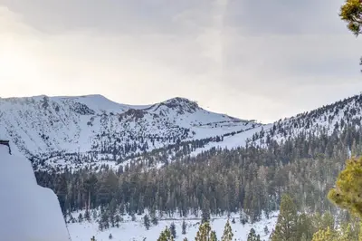 a snowy mountain with trees and mountains in the background at Mammoth Lakes Condo - Steps to Ski Lift! in Mammoth Lakes