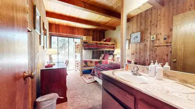 a bathroom with a sink and a bedroom with a bed at Villa de los Pinos #40 condo in Mammoth Lakes