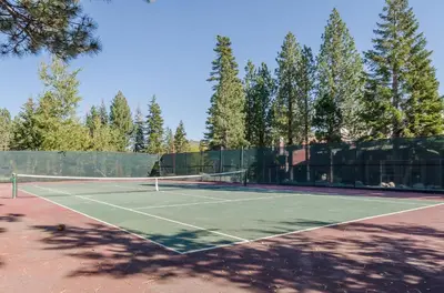 a tennis court with a net and some trees at New Listing 2 bedroom +Loft 2 bath Summit E Bldg. #8 condo sleeps 8, Steps to Eagle Lodge/Chair #15 in Mammoth Lakes