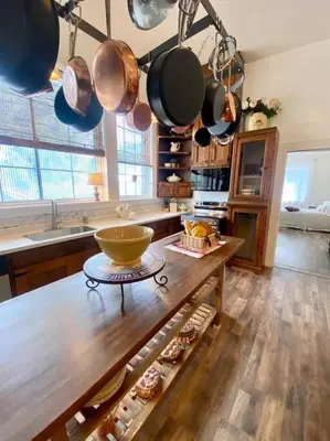 a kitchen with a wooden table and pots and pans at The Shopkeeper's Cottage ~ CHIC! in Amador City