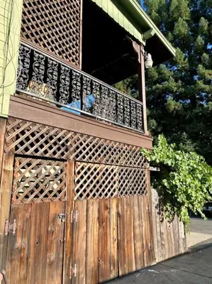 a wooden gate with a balcony on a house at The Shopkeeper's Cottage ~ CHIC! in Amador City
