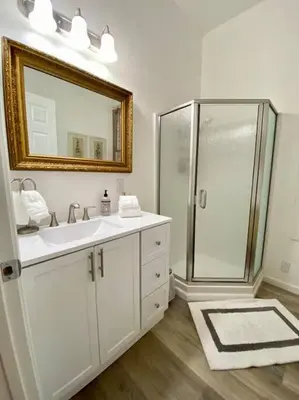 a bathroom with a shower and a sink and a mirror at The Shopkeeper's Cottage ~ CHIC! in Amador City