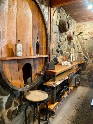a room with a table and a chair and a barrel at Vintage 1857~Stone & Beam Cellar in Amador City