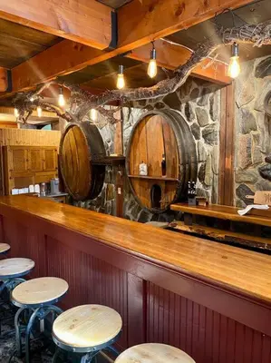 a bar with some tables and somebeer barrels at Vintage 1857~Stone & Beam Cellar in Amador City