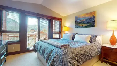 a bedroom with a bed and windows with a view at Juniper Crest #2 townhouse in Mammoth Lakes