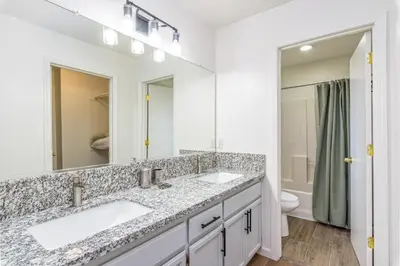 a bathroom with two sinks and a toilet at 3BR Cozy Home~ Stylish & New ~ UC Merced ~ en route Yosemite! in Merced
