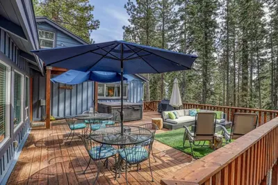 a patio with a table and chairs and an umbrella at Classic 3BD Tahoe Cabin with Hot Tub in Carnelian Bay