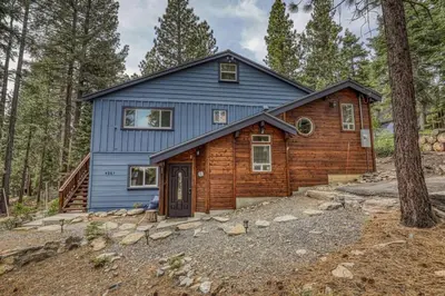 a blue house in the middle of a forest at Classic 3BD Tahoe Cabin with Hot Tub in Carnelian Bay