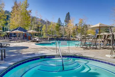 a pool at a resort with chairs and umbrellas at Breathtaking Olympic Valley Gem Walk to Chairlift in Olympic Valley