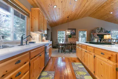 a kitchen with wooden cabinets and a wooden ceiling at Alpen Glow by Tahoe Getaways - Private Hot Tub, Close to Northstar in Carnelian Bay
