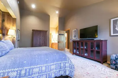 a bedroom with a bed and a flat screen tv at Alpen Glow by Tahoe Getaways - Private Hot Tub, Close to Northstar in Carnelian Bay