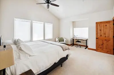 a bedroom with a bed with a ceiling fan and a desk at Agate Bay Gem by Tahoe Getaways - Charming Getaway with Cozy Fireplace Near Hiking and Biking Trails in Tahoe Vista