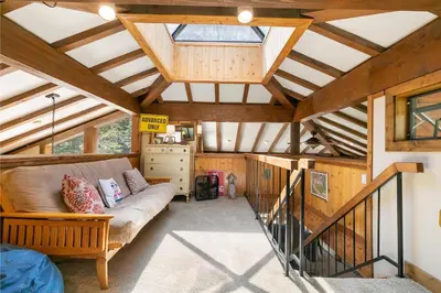 a living room with a couch in a room with wooden ceilings at Alpine Escape by Tahoe Getaways - Shuttle to Ski Slopes & Fireplace in Alpine Meadows