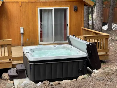 a hot tub sitting on a deck next to a house at Bear's Lair by Tahoe Getaways - 3 BR in Tahoe Donner with Hot Tub & Bonus Room! in Truckee