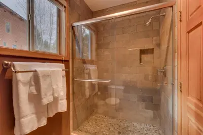 a shower with a glass door in a bathroom at Bitter Brush by Tahoe Getaways -4 BR Pet Friendly, Northstar Home with Hot Tub, Pool Table, & Ski Shuttle in Truckee