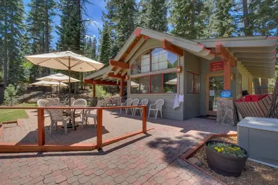 a patio with a table and chairs and an umbrella at Bitter Brush by Tahoe Getaways -4 BR Pet Friendly, Northstar Home with Hot Tub, Pool Table, & Ski Shuttle in Truckee